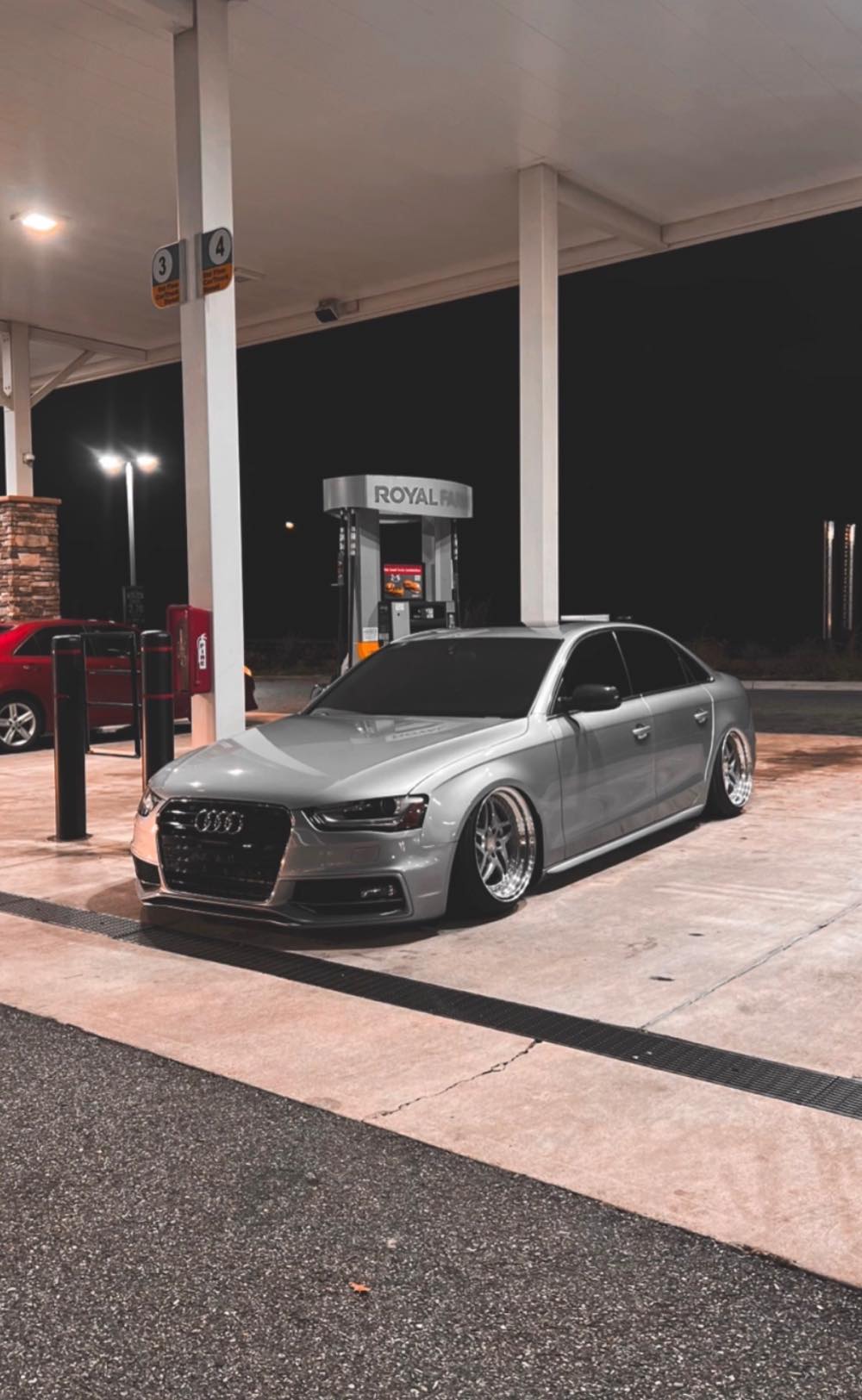 Silver Audi A4 with dark window tint at night