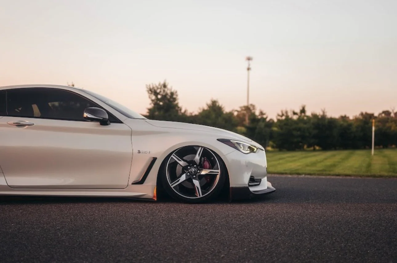 White Infiniti Q60 coupe aired out on air suspension at sunset