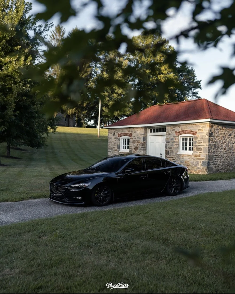 Blacked-out Mazda 6 with dark tint on air suspension