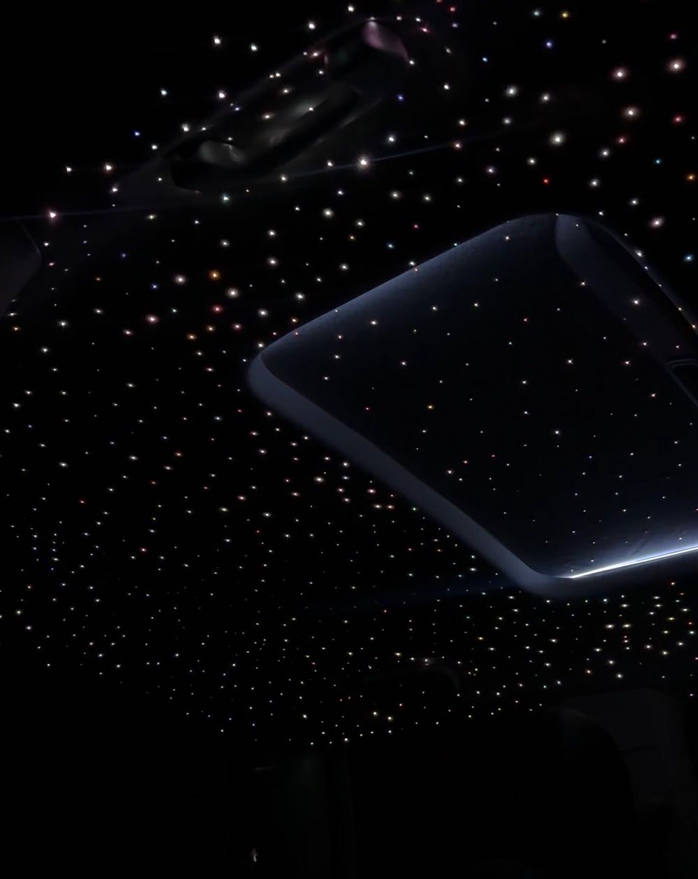 Fiber-optic starlight headliner glowing around a sunroof